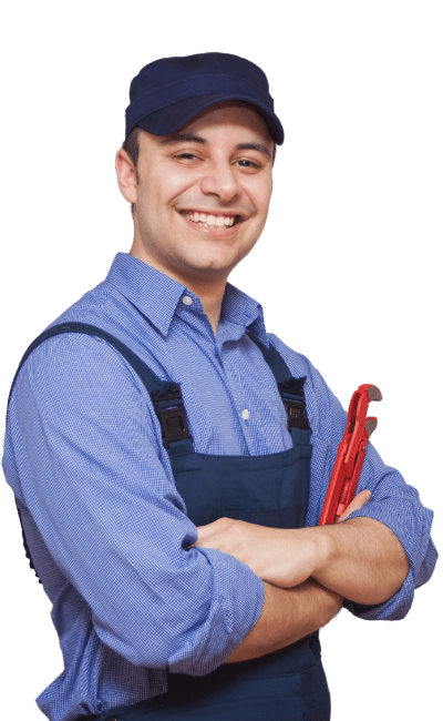 Man smiling in blue shirt, overalls and hat with arms crossed holding a red wrench